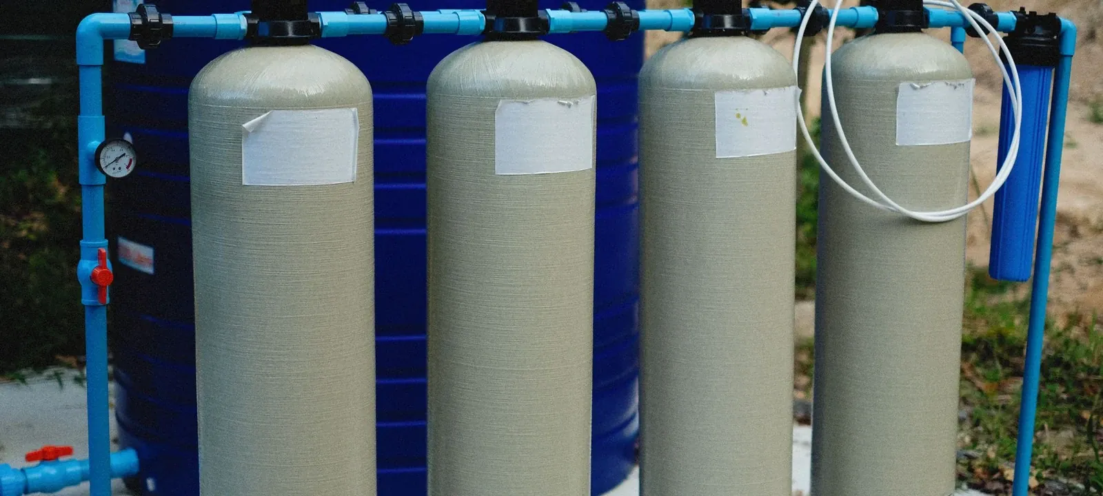 Row of water treatment tanks connected with blue pipe
